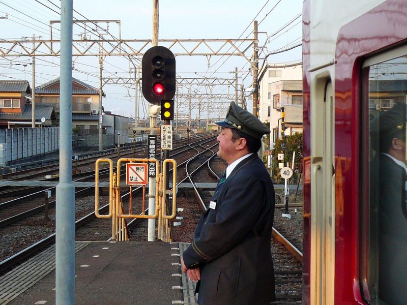 Der Kintetsu-Konzern - die Ueberholung (2): Der Schaffner (ein sichtlich zufriedener Mann), der sich im hinteren Führerstand des Zuges (Wagen 9103) aufhält, stellt sich jetzt neben seinen Zug, um die Ueberholung zu verfolgen. Ise Wakamatsu, 26.Februar 2009.