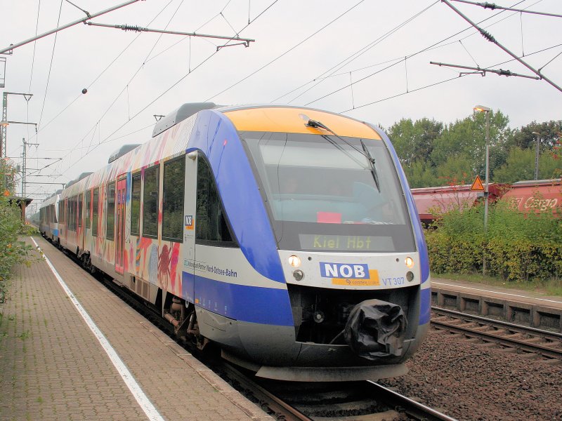 Der mit  Strand- und Urlaubsmotiven  ausgestattete VT307 der Nord-Ostsee-Bahn fhrt mit einem weiteren NOB-Triebwagen in Jbek ein. Der Zug kommt von Husum und fhrt nach Kiel.