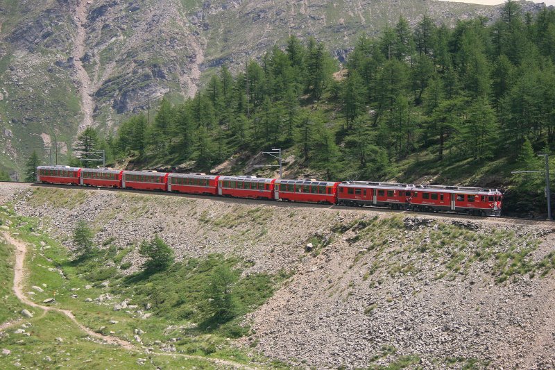 Der Mittags-Berninaexpress 973 mit Triebwagen 56 und 53 hat die Passhhe bereits berquert und befindet sich im ersten Abstieg zur Alp Grm. Aufnahme am 31.7.2008 beim Pozzo del Drago. 