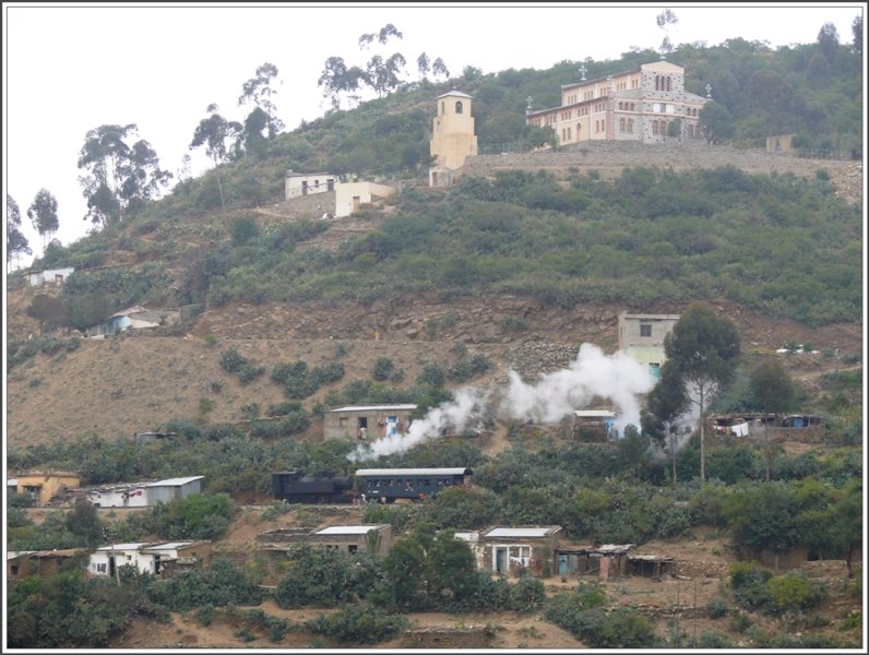 Der nachfolgende Dampfzug hlt an der Ausweichstelle Shegerini zwischen Asmara und Arbaroba. Da es in Eritrea ca je 50% Muslime und Christen hat, sieht man auch immer wieder Kirchen, Klster und Moscheen. (29.10.2008)