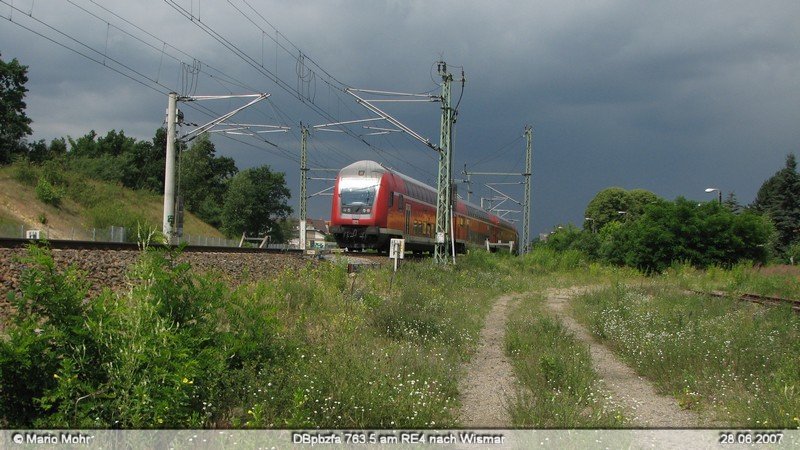 Der RE4 nach Wismar bei der Einfahrt in Falkensee, gezogen von 114 040.