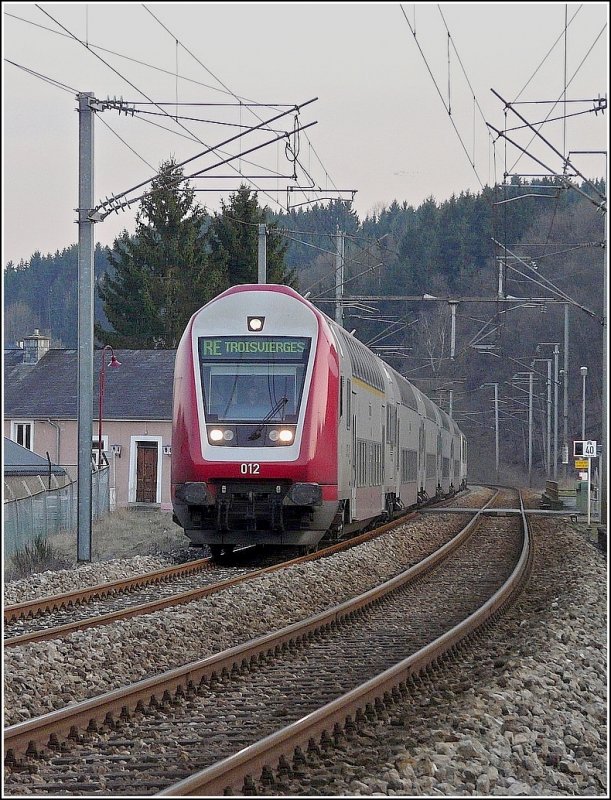 Der Regionalexpress (Verstrkungszug) nach Troisvierges fhrt am 19.03.09 durch die Ortschaft Enscherange, geschoben von einer Lok der BR 3000. (Jeanny)