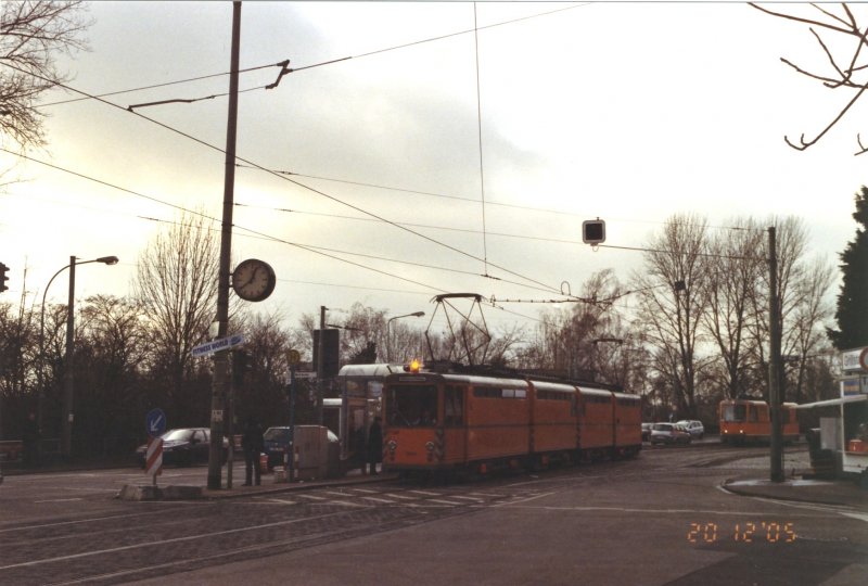 Der Schienenschleifzug an der Haltestelle Nied Kirche kurz nachdem er die dortige Wendeschleife verlassen hat.Dahinter schleicht die Akkulok aus der Wendeschleife sich langsam ins Bild am 20.12.2005