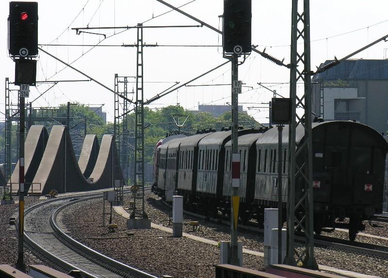 Der Sonderzug mit historischen Wagen zum Bahntag in Elstal fhrt am 21.5.2005 aus dem Bahnhof Berlin Spandau nach Ruhleben zum Wenden. Geworben wurde mit einer 52er Dampflok. Doch die wurde schadhaft. Als Ersatz fuhr ein E-Lok. Rabatt gab es dafr aber nicht! Im Hintergrund die  Innovative 7gleisige Brcke ber die Havel . Die unmglichste Eisenbahnbrcke in Deutschland. Sie will beim Befahren abheben und mute deshalb rckverankert werden. Mehrkosten ca 8 Mio DM, die sich die Stadt Berlin und die Deutsche Bahn teilten