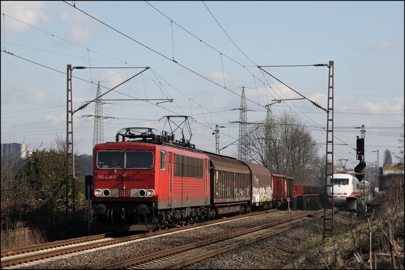 Der  Stromcontainer  155 228 ist noch mit langen Kontrastbalken unterwegs und schleppt einen langen Gterzug, groteil davon waren Leerwagen, von Hagen-Vorhalle in Richtung Witten. (07.03.2009)
