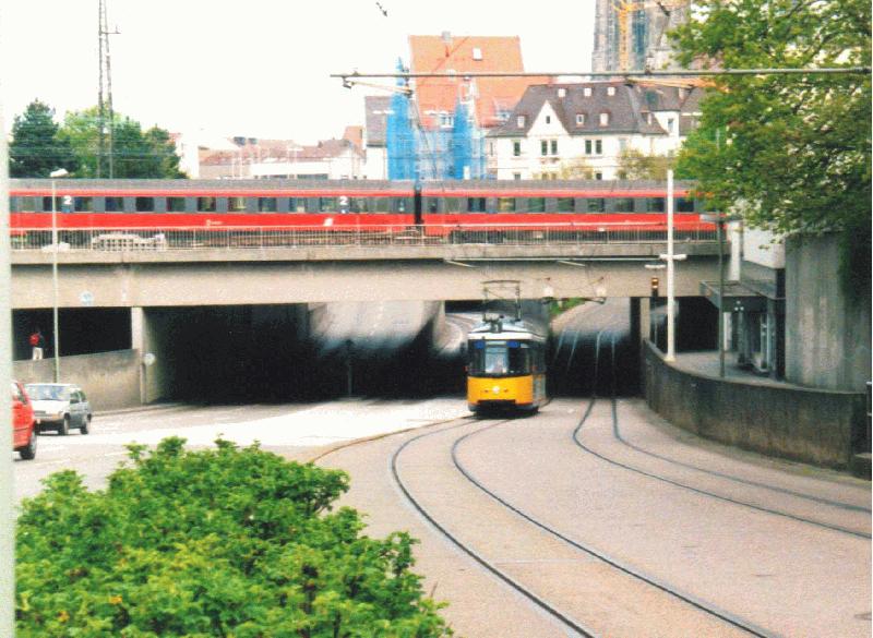 Der Triebwagen Nr. 7 der Ulmer Straenbahn (Typ GT 4 der Maschinenfabrik Esslingen) unterquert am frhen Nachmittag des 23. April 2002 gerade die Bahnlinie Stuttgart-Mnchen in der Nhe des Ulmer Hauptbahnhofes, als zur gleichen Zeit oben der EC  Mozart  Ulm verlsst.