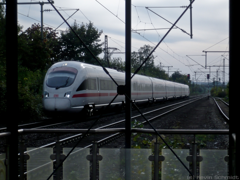 Der von der Überdachung einer Bahnsteigunterführung durchgestrichene ICE 1704 nach Berlin Gesundbrunnen durchfährt den Bahnhof Bad Staffelstein. Nächster Halt wird in Kürze Lichtenfels sein. (28.09.2009)