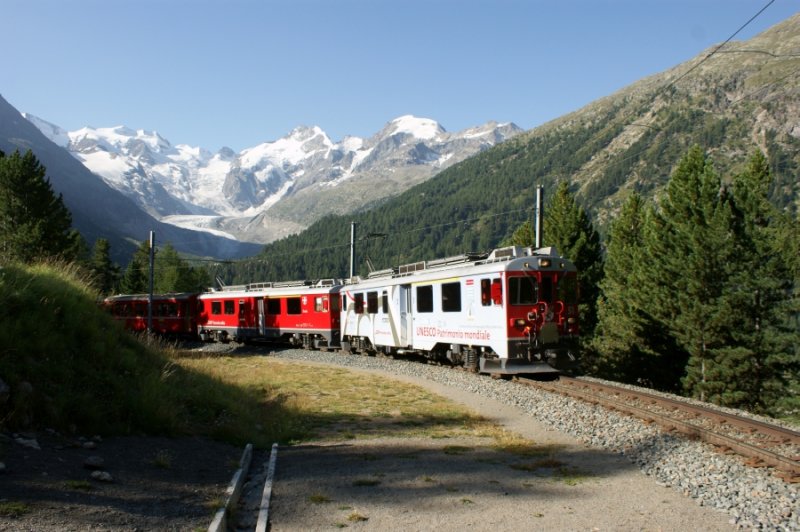 Der Unesco-Triebwagen ABe 4/4 III 51 erreicht mit seinem Zug die bekannte Montebellokurve. Das Panorama mit Morteratschgletscher, Piz Pal, Piz Bernina und Bellavista ist beeindruckend. 14. August 2009, frher Morgen.
