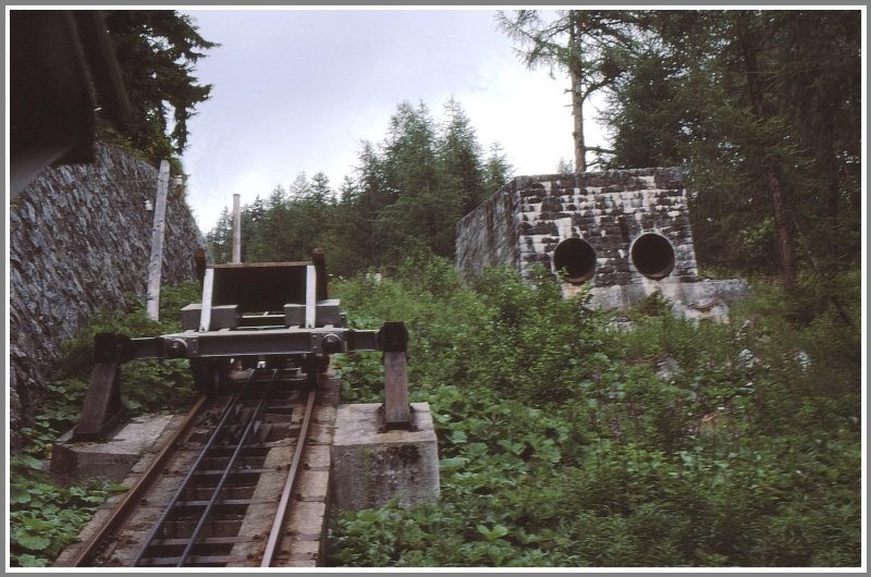 Der zustzliche Gewichtswagen wartet mitten auf der Strecke an einem Prellbock, um mitgestossen zu werden. (Archiv 08/94)
