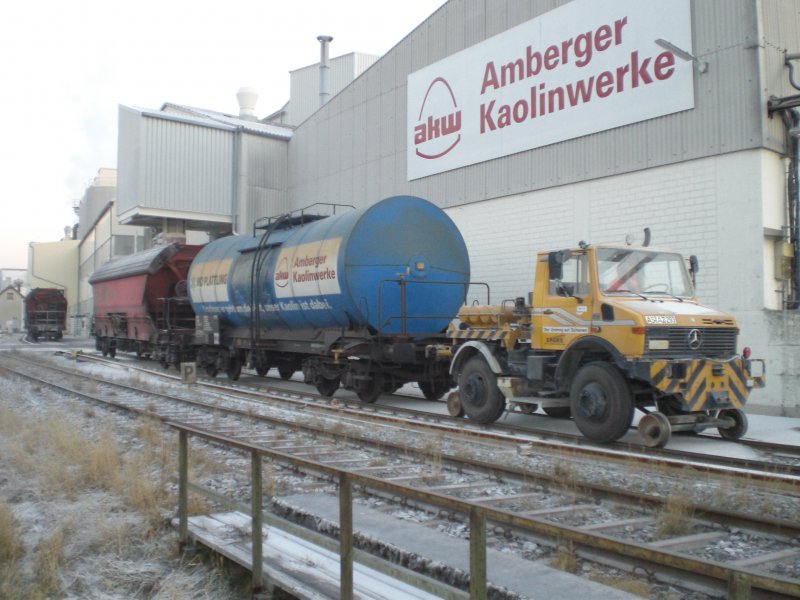 Der Zweiwege-Unimog der Amberger-Kaolinwerke mit einem Kesselwagen fr Plattling und einem Schttgutwagen fr Plattling an der Kaolinverladestelle! (Hirschau, 21.12.2007, Strecke Amberg-Schnaittenbach)