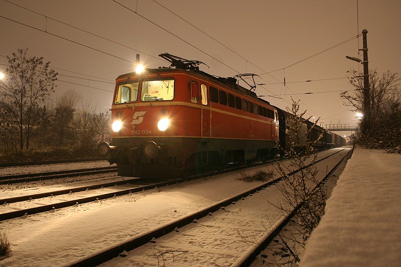Des nchtens am 26. November 2005 steht die 1042 034 mit ihrem 51097 in Simmering Ostbahn. Im Hintergrund die Haltestelle Grillgasse.
Die Lok gibt es leider mittlerweile nicht mehr.