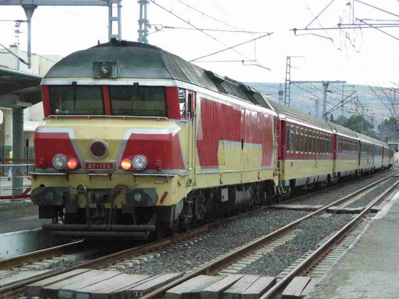 DF-109 setzt sich vor den Zug und wird den aus Fes angekommenen Schnellzug weiter auf der nicht elektrifizierten Strecke nach Tanger ziehen.
Die Baureihe DF des ONCF ist mit 2650 kW/3600PS die leistungstrkste Dieselokreihe in Marokko. Sie ist baugleich mit der franzsischen Reihe CC72000 der SNCF.
Sidi-Kacem 24.01.2007