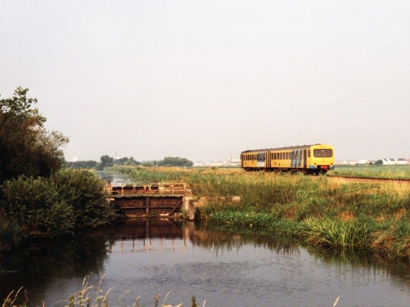 DH II 3207 mit Regionalzug 8621 Leeuwarden-Groningen neben das alte Schleusenwerk in die Tytsjerksterfeart bei Leeuwarden am 06-08-1990. Bild und scan: Date Jan de Vries.