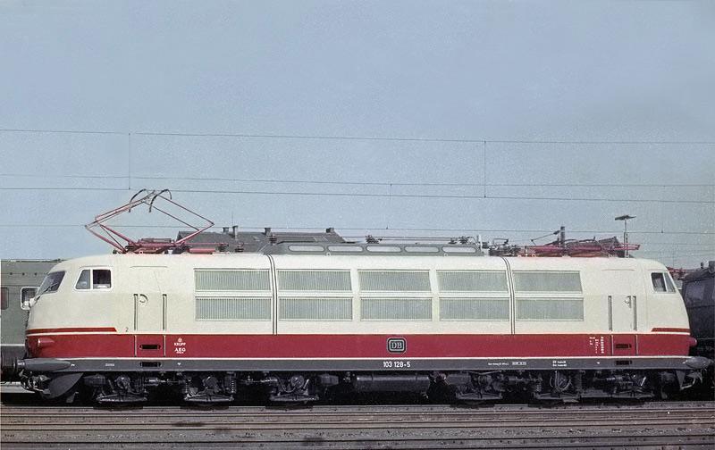Die 103128 vom Bw Frankfurt wird  aufgerstet und bereitgestellt
fr einen F-Zug nach Mnchen.
An der Lok ist noch der alte Bgel,(Stromabnehmer) einschlielich
der damals blichen Frontschrzen, unterhalb der Puffer, vorhanden. 
Die Aufnahme stammt etwa von 1969 und wurde neu eingescannt.
Kodak-Negativ. Kamera Minolta SRT1
