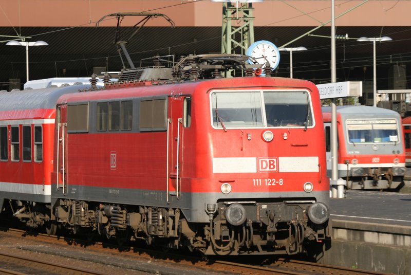 Die 111 122-8 mit dem pnktlichen RE4 Verstrker verlsst Dsseldorf HBF whrend die RB38 im Hintergrund mit einem 928er einfhrt, aufgenommen am 10.10.2009