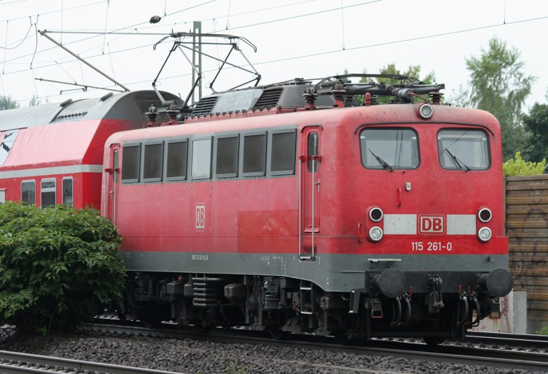 Die 115 261-0 zieht den Schadzug mit einem Ost-Dosto, Silberlingen und IC-Wagen durchfuhr Kln Porz am 12.07.2009