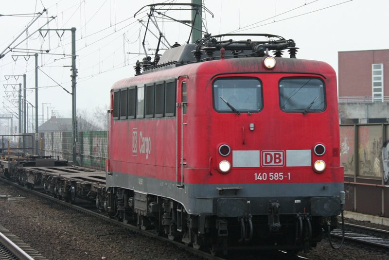 Die 140 585-1 zieht Flachwagen durch Kln Ehrenfeld am 23.12.2008
