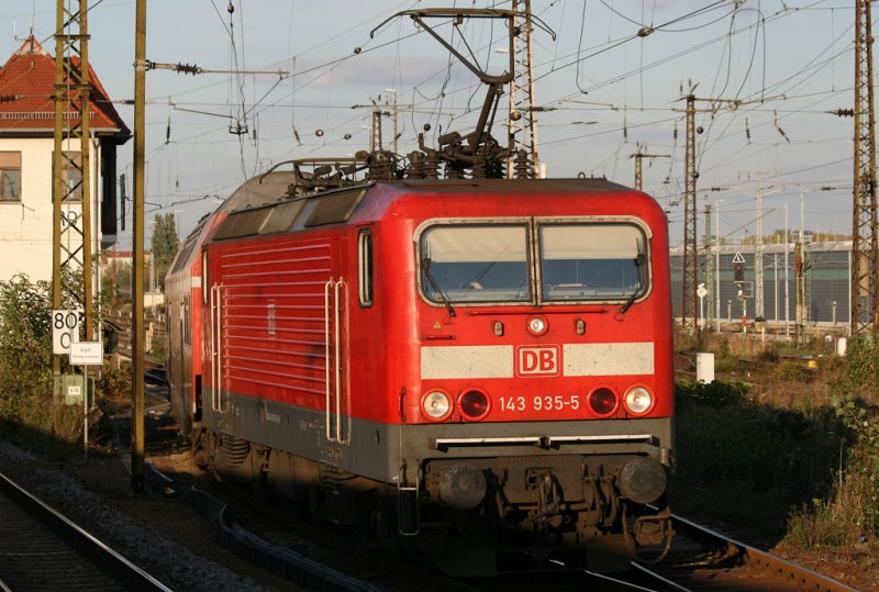 Die 143 935-5 steht im Leipziger Bahnhofs Vorfeld mit einer S-Bahn Garnitur, aufgenommen aus einem fahrenden Zug am 19.10.2009