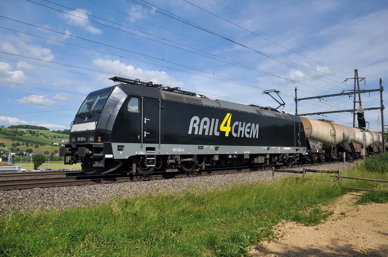 Die 185 563-4 der RAIL4CHEM mit einem Kesselzug zu Gast in der Schweiz, genauer im Fricktal im Aargau, auf der Fahrt in Richtung Basel. Das war sehr knapp bei diesem Foto. Ich sass im Auto, als die  Schwarze  um die Kurve, ca. 300m entfernt kam. Raus und 30m in Fahrtrichtung gesprungen, Kamera ans Auge,ausgelst und froh danach ber die Aufnahme. Frick im Kanton Aargau am 3.6.2009.