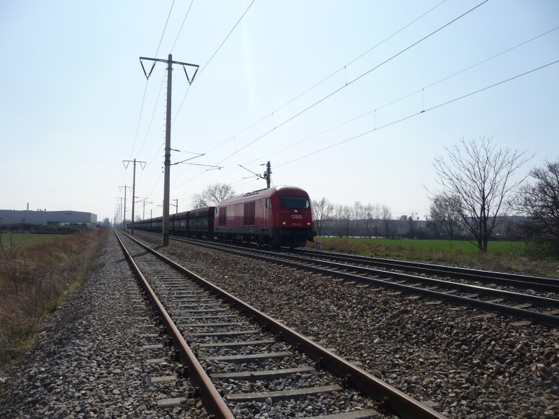 Die 2016 005-7 zieht einen Schotterzug aus der Bahnhaltestelle Breitenleer Stra�e. (02.04.09)