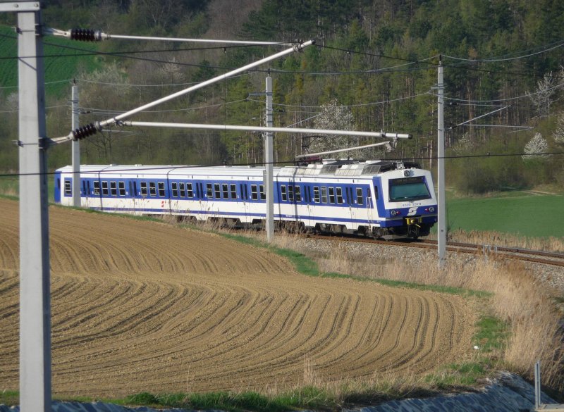 Die 4020 231-9 befindet sich gerade zwischen den Bahnhaltestellen Hrersdorf und Frttingsdorf. Gleich wird die Einfachgarnitur hinter dem Berg verschwinden. (Niedersterreich, 12.04.09)