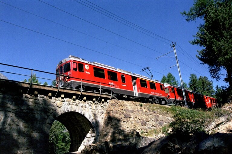 Die ABe 4/4 53 und 56 fahren mit einem Regio nach St.Moritz auf die Brcke des Berninabaches oberhalb Morteratsch im August 2003.