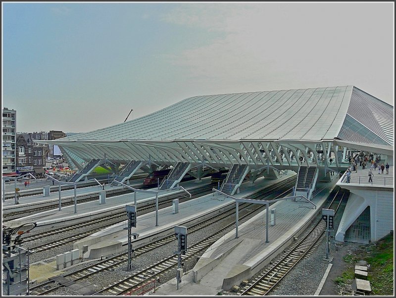 Die Autobahnausfahrt zum Bahnhof Lige Guillemins war am 20.09.09 fr die zahlreichen Besucher zugnglich und so konnte die auf 39 Haupttrger gesttzte weie Kontruktion aus Stahl und Glas auch einmal von dieser Seite fotografiert werden. Aus dieser Sicht gleicht das Dach einer gigantischen Welle und steht im Kontrast zu der stdtebaulichen Oede der angrenzenden Straen. (Jeanny)