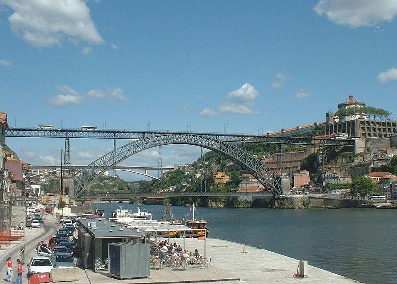 Die ber�hmte Hochbr�cke �ber den Doure in Porto. Noch fahren unten und oben �ber die Br�cke Kraftfahrzeuge, aber ab Mai 2004 soll oben statt der Omnibuse die Metro �ber die Br�cke fahren, wenn die Termine eingehalten werden. Im Hintergrund ist die neue Betonstrassenbr�cke sichtbar, sie ist schon in Betrieb.