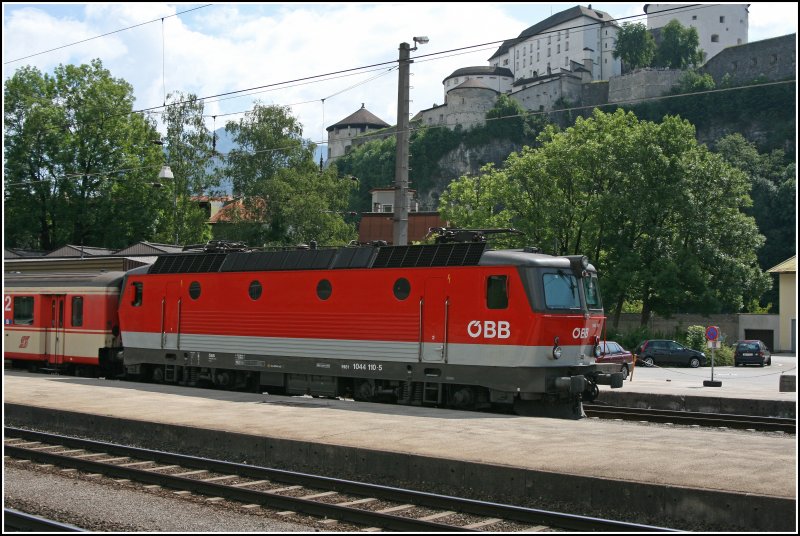Die Bludenzer 1044 110 steht mit einer Schlierengarnitur auf dem Seitengleis in Kufstein. Oberhalb der Lok trohnt die Festung Kufstein.