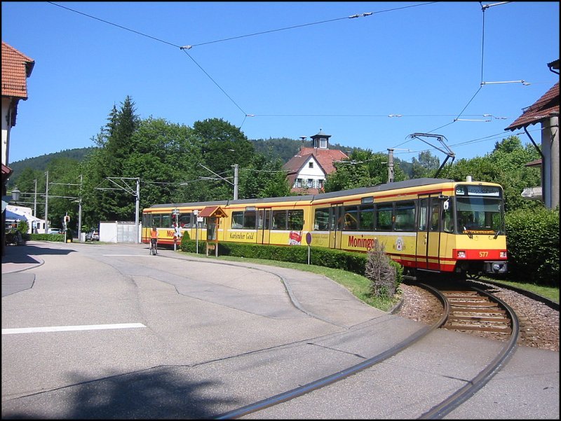 Die Einfahrt der Stadtbahnen in den Bahnhof von Bad Herrenalb erfolgt ber die Wendeschleife um das Bahnhofsgebude herum. Hier fhrt gerade ein Zug der Linie S1 ein. Es wird bereits Leopoldshafen als Ziel fr die Rckfahrt angegeben. Die Aufnahme stammt vom 02.07.2006.