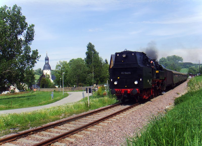 Die erste von zwei Pendelfahrten fhrte 65 1049-9 Tv nach Schwarzenberg. Hier verlt der Zug Schlettau, links im Bild zu sehen die St.-Ulrich-Kirche, 21.05.2009.
