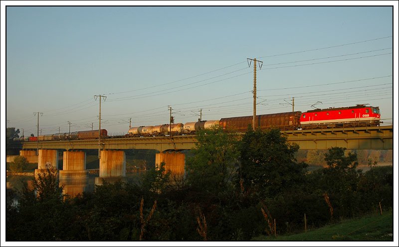 Die ersten Sonnenstrahlen in der Wiener Lobau am 30.9.2007. 1044 101 bei der Querung der Neuen Donau mit ihrem Gterzug Richtung Stadlau.