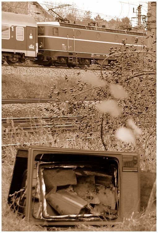 Die formschne, blutorange 1044 040 rauscht in Wien Simmering

an einem neben dem Bahndamm entsorgten Fernsehapparat vorbei ...
