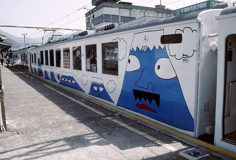 Die Fujiky-Bahn: Deutlich zeigt der Anstrich, dass hier geworben wird um junge Familien aus Tokyo, die mit ihren Kindern einen Wochenendausflug machen sollen. Im Bild der Mittelwagen (Nr.2101) einer der beiden Panoramazge (3-Wagenzge) Serie 2000. tsuki, 2.April 2002. 