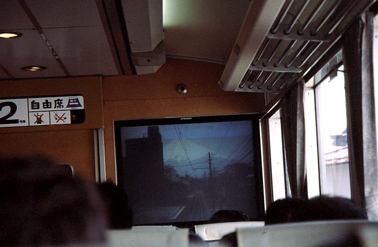 Die Fujiky-Bahn: Im Mittelwagen des Panoramazuges knnen die Fahrgste die Panoramasicht ber Monitor mitgeniessen. Der Zug fhrt frontal auf den Berg Fuji zu. Bei Mitsutge, 2.April 2002.