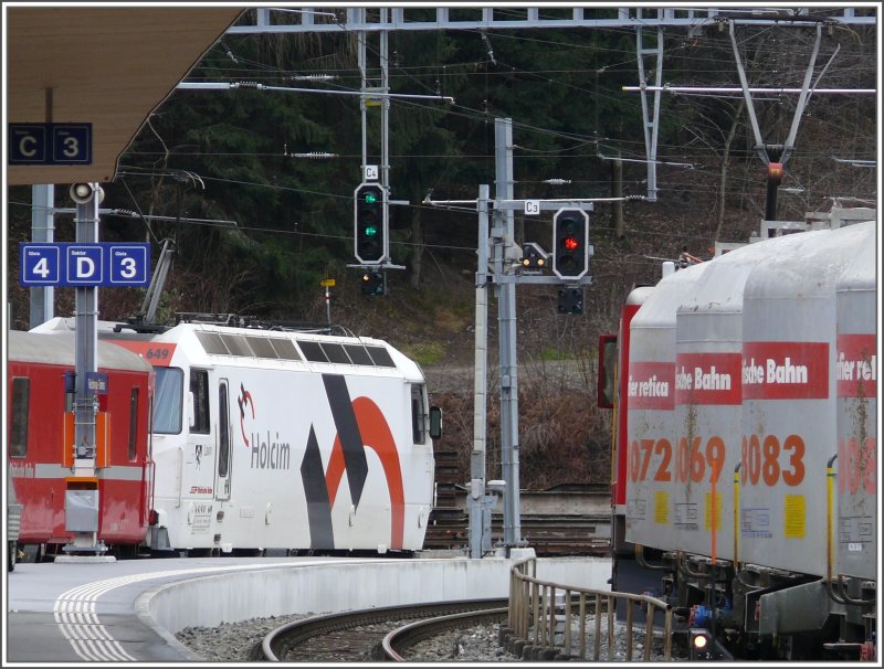 Die Ge 4/4 III 649  Lavin  (mit Zementwerbung) berholt in Reichenau-Tamins einen Zementzug. (10.12.2007)
