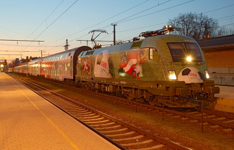 Die Gesamt EM Werbelok 1116 264-1 in gr�n gehalten, mit allen teilnehmenden Nationen nach Sonnenuntergang im Bahnhof Stockerau fotografiert. Das Foto ist am 26.02.2008 entstanden.