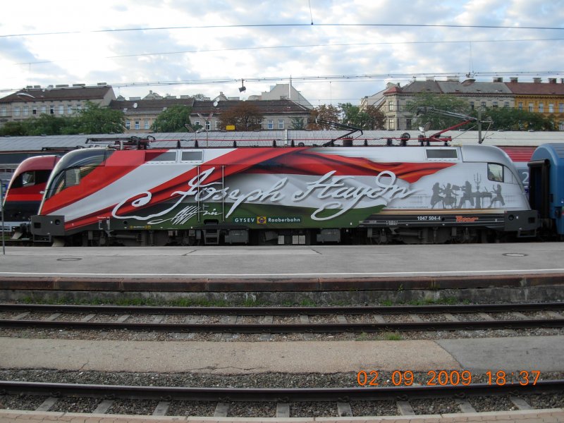 Die Haydn-Lok vor dem  Dacia , mit dem sie in wenigen Minuten den Wiener Westbahnhof verlassen wird. Der nchste Geniestreich der Knstlerin Gudrun Geiblinger, die inzwischen bereits etliche groartige Sonderloks entworfen hat. Wie armselig wirken da im Vergleich dazu Machwerke a la  Telekom Austria  oder auch  SIEMENS  (2.9.2009).