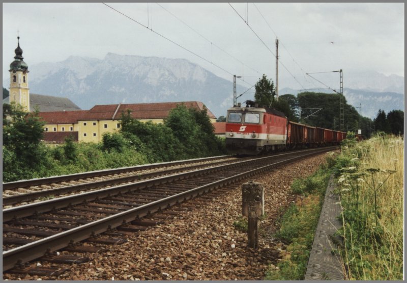 Die Innsbrucker 1144 206 befrdert einen Gterzug vom Bahnhof Brenner nach Mnchen das Kloster Reisach. Im Hintergrund erhebt sich das Kaisergebirge. Aufgenommen im Sommer 2005.