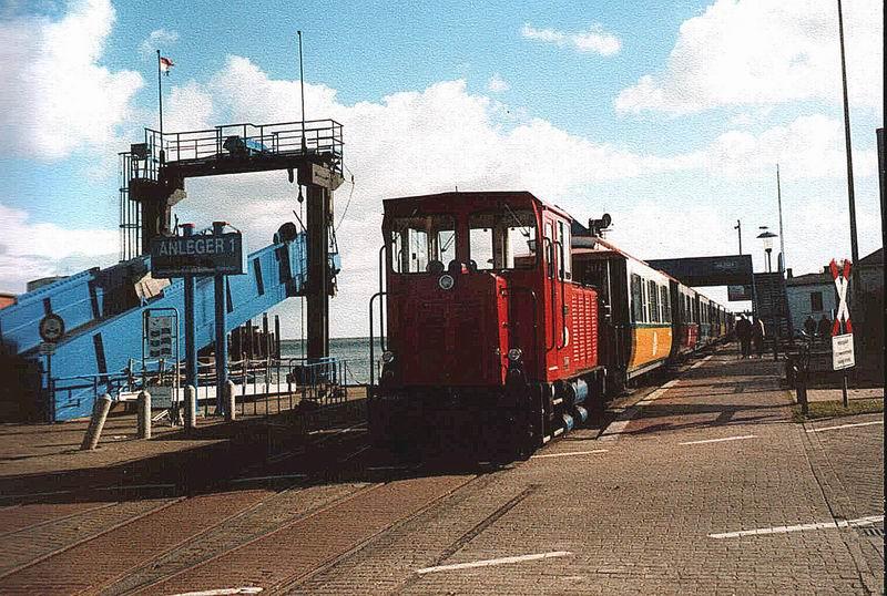 Die Inselbahn Borkum ist am Hafen angekommen,die Lok hat Kopf gemacht und sich wieder an die Ort-Seite gesetzt.Allerdings muss vor der Abfahrt das Ankommen der Fhre aus Emden abgewartet werden.