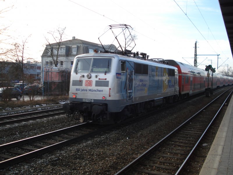 Die Jubilumslok  850 Jahre Mnchen  (111 027-9) schiebt am 05.02.09 ihren RE durch Mnchen-Trudering.
