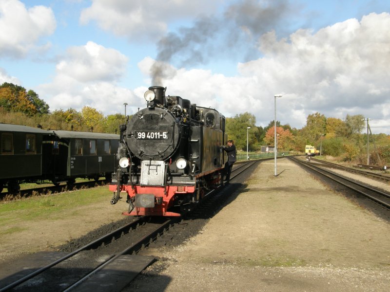 Die Lok 99 4011 setzt sich in Putbus an einen Personenzug nach Ghren.