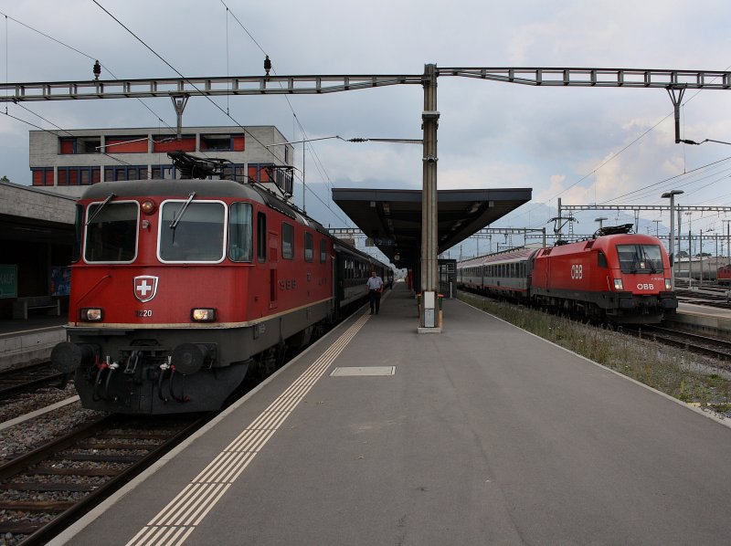Die Re 4/4 11220 mit einem IR und die 1116 262 mit dem EC nach Wien am 01.07.2009 in Buchs. 