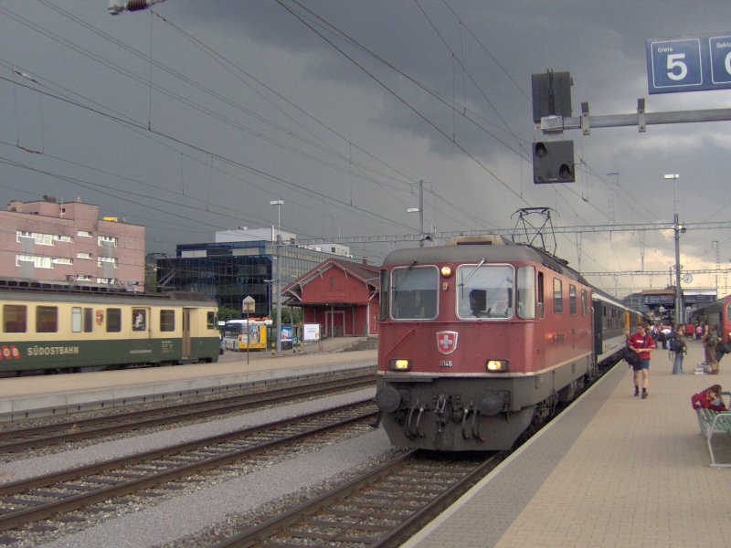 Die Re 4/4 II 11146 macht whrend eines aufkommenden Gewitters mit ihrem IR nach Chur einen Halt in Pfffikon SZ,und auf Gleis 2 fhrt ein BDe 576 der SOB ein. 