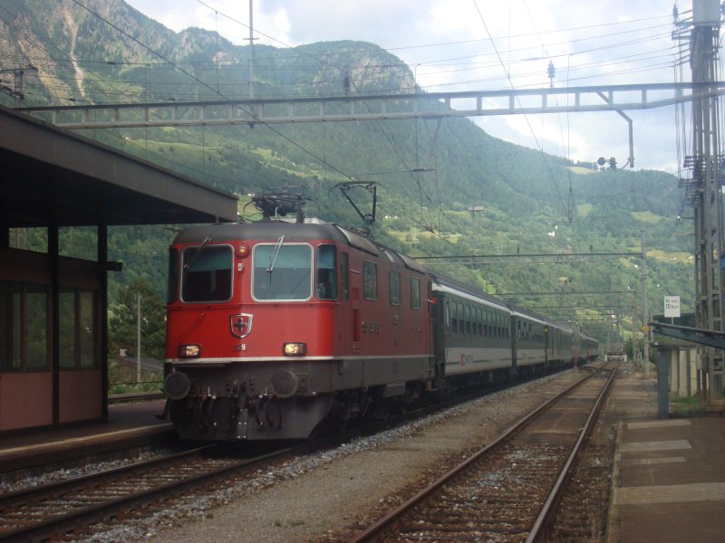 Die Re 4/4 II 11159 durchfhrt am 27.6.2007 mit ihrem Schnellzug den Bahnhof Ambri-Piotta.