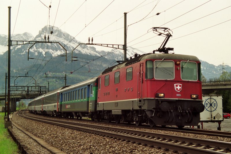 Die Re 4/4 II 11198 unterwegs mit einem EC bei Schwyz im Sommer 2005.