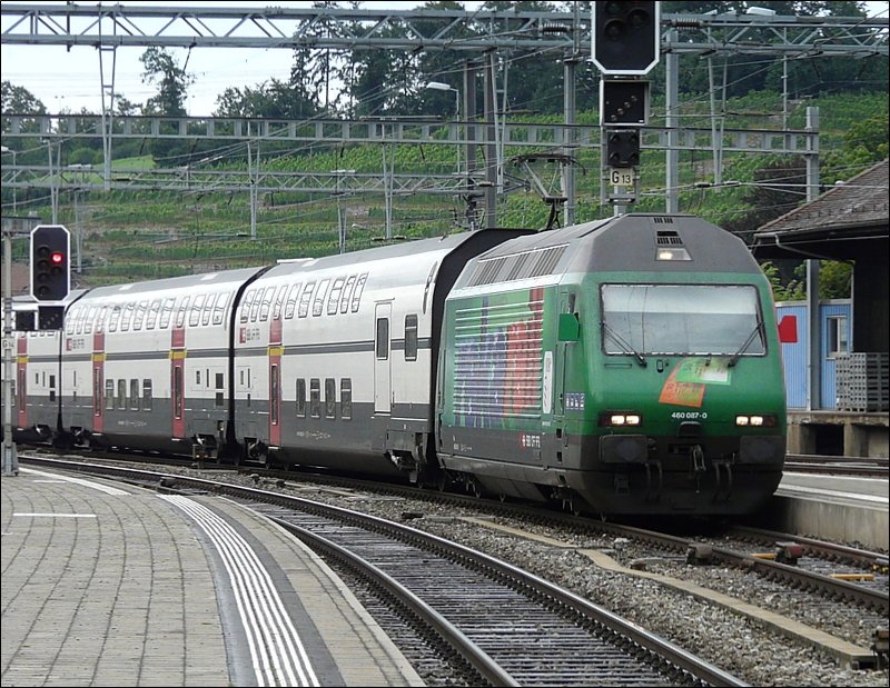 Die Re 460 087-0 mit ihrer Werbung fr Reka Rail kommt am 29.07.08 an der Spitze des Zuges im Bahnhof von Spiez an. Im Hintergrund sieht man, dass auch in Spiez ein durchaus sffiger Rebensaft angebaut wird. (Jeanny)