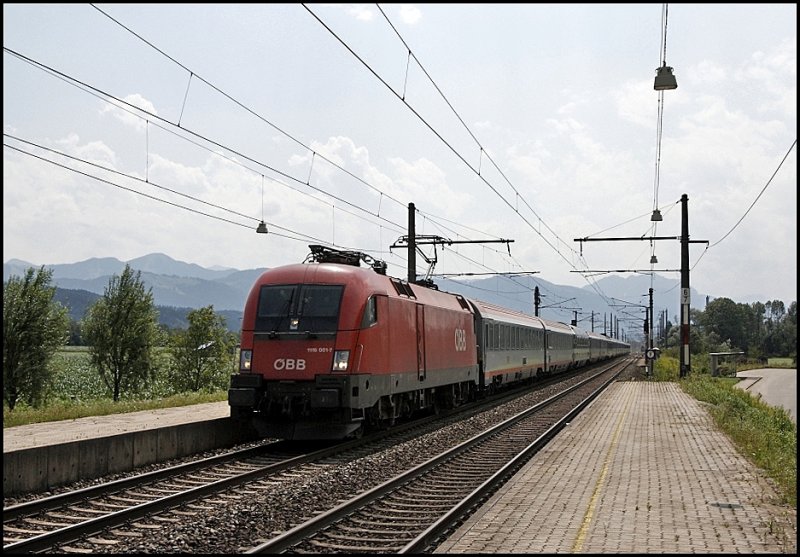 Die Ruhe vor dem Sturm: 1116 001 rast mit dem OEC 163  TRANSALPIN , Basel SBB - Wien Westbahnhof, durch den Haltepunkt Langkarpfen in Richtung Kufstein. (02.08.2009)
