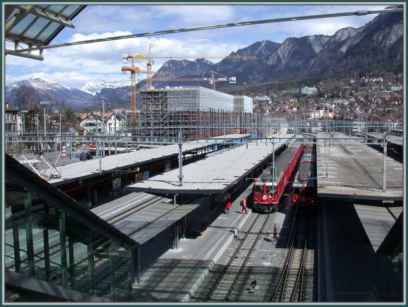 Die Seite der RhB mit den Geleisen 10 - 14. Auf Gleis 10 der Schnellzug nach St.Moritz und auf Gleis 11 der RegioExpress nach Disentis. Im neuen Gebude im Hintergrund werden gegen 1000 Schler Platz finden. Chur. (02.04.2007)