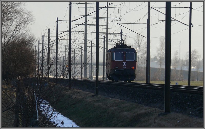 Die Sonne hat sich soeben hinter dem Calanda verabschiedet, whrenddem auf dem rechten Streckengeleise die Re 4/4 II 11269 Richtung Zementwerk Untervaz fhrt, um Silowagen abzuholen. (28.12.2007)